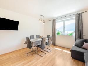 a dining room with a table and chairs and a couch at Beautiful apartment in Hart im Zillertal with mountain view in Hart im Zillertal