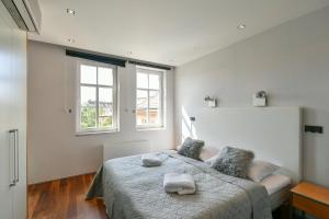 a bedroom with a large bed with two windows at LUXURY CENTRAL PENTHOUSE WITH SAUNA, TERRACE, 250m2, 5BDRM, 3BTHRM in Prague