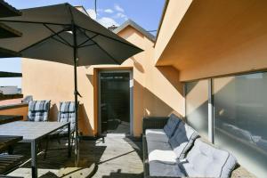 eine Terrasse mit einem Tisch, Stühlen und einem Sonnenschirm in der Unterkunft LUXURY CENTRAL PENTHOUSE WITH SAUNA, TERRACE, 250m2, 5BDRM, 3BTHRM in Prag