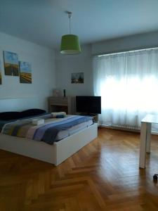 een slaapkamer met een bed en een houten vloer bij 4 minutes from Lausanne Train Station in Lausanne