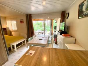 ein kleines Wohnzimmer mit einem Tisch und einer Küche in der Unterkunft LES COTTAGES DE LEON in Léon