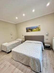a bedroom with two beds and a painting on the wall at Relais Milò in Agerola +21 photos