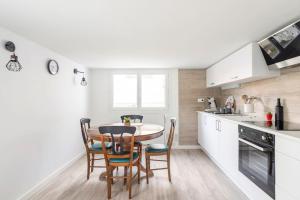uma cozinha e sala de jantar com mesa e cadeiras em Appartement 200 m plage avec terrasse et jardin em Royan