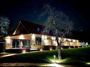 una casa iluminada por la noche con luces en DRIEHOF LandGut & Residenz LifeStyle Suite Apt 6 en Tecklenburg