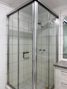 a shower with glass doors in a bathroom at Marina View Holiday Apartment - Beautiful Views in Larrakeyah