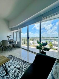 a living room with a couch and a large window at Marina View Holiday Apartment - Beautiful Views in Larrakeyah