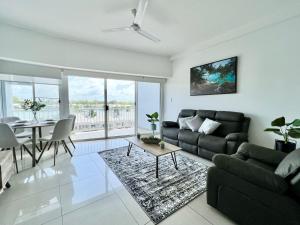 a living room with a couch and a table at Marina View Holiday Apartment - Beautiful Views in Larrakeyah