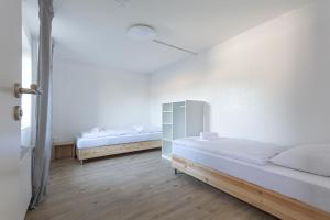 um quarto branco com 2 camas e uma janela em T&K Apartments Wegberg 5 Monteur Apartments em Wegberg