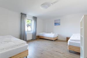 1 dormitorio con 2 camas y ventana en T&K Apartments Wegberg 5 Monteur Apartments en Wegberg