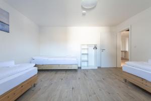 Habitación blanca con 2 camas y armario en T&K Apartments Wegberg 5 Monteur Apartments, en Wegberg