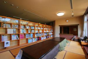 una biblioteca con una mesa y estanterías de libros en hokkein-onsen kougen-terrace, en Kokonoe