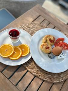 a table with two plates of food and an egg and orange slices at Senator in Ulcinj