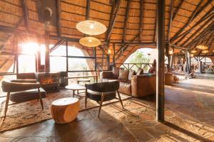 a living room with a couch and a table and chairs at Vingerklip Lodge in Fingerklippe 