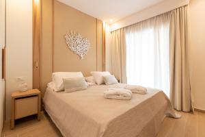 1 dormitorio con 1 cama grande y toallas. en The 12th City Hotel en Rodas