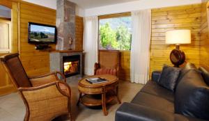 sala de estar con sofá y chimenea en Apart Hotel Le Temps Des Cerises en San Martín de los Andes