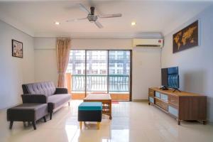 ein Wohnzimmer mit einem Sofa und einem TV in der Unterkunft Borneo Peak - Marina Court Seaview Condominium in Kota Kinabalu