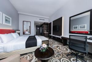 a hotel room with a large bed and a desk at Raia Hotel & Convention Centre Kuching in Kuching