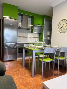 cocina con mesa, sillas y reloj en Apartamento Marichu, en Melide