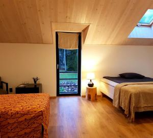 a bedroom with two beds and a large window at Hõbekala Guesthouse in Kalana