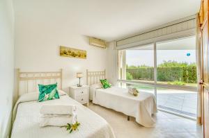 ein Schlafzimmer mit zwei Betten und einem großen Fenster in der Unterkunft Ideal Property Mallorca - Villa Anna in El Port