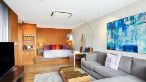 sala de estar con sofá y cama en Relax Resort Hotel, en Atami
