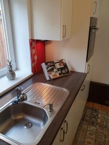 um balcão de cozinha com um lavatório e uma janela em Ferienbungalow Juri am Millstätter See em Döbriach