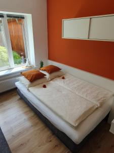 - 2 lits dans une chambre avec un mur orange dans l'établissement Ferienbungalow Juri am Millstätter See, à Döbriach