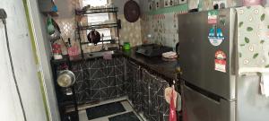 a small kitchen with a refrigerator and a stove at Homestay Hamdan in Bagan Pulau Betung