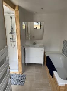ein Badezimmer mit einer Badewanne und einem Waschbecken in der Unterkunft Luxurious Garden Cottage in Argelès-Gazost