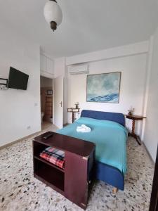 a bedroom with a blue bed and a table at My Room Roma 2 in Lido di Ostia