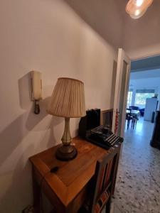 a lamp on a wooden table in a living room at My Room Roma 2 in Lido di Ostia