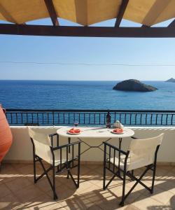 een tafel en stoelen met uitzicht op de oceaan bij Villa Koutsakis in Kali Limenes