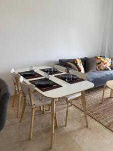 Penthouse familial avec vue mer في مانيلفا: طاولة وكراسي في غرفة معيشة مع أريكة