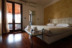 una camera con un grande letto con una panca di Villa Roberta B&B a Ferrara