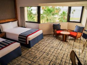 um quarto de hotel com duas camas e uma mesa e cadeiras em The Luigans Spa and Resort em Fukuoka