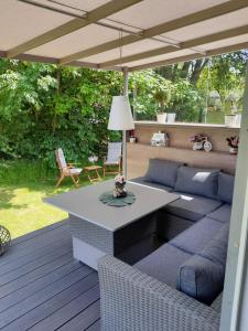 un patio con sofá y una mesa en una terraza en Tiny House am Elsbach in der bayerischen Rhön., en Oberelsbach