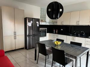 a kitchen with a table with chairs and a refrigerator at Sweet Dream in Acitrezza