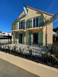 a house with a fence in front of it at Sumner Surf Break Apt 2 in Christchurch