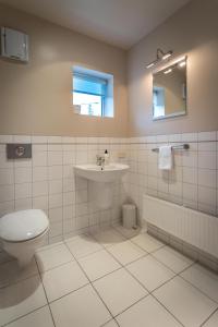 a bathroom with a toilet and a sink and a mirror at Sumner Surf Break Apt 2 in Christchurch