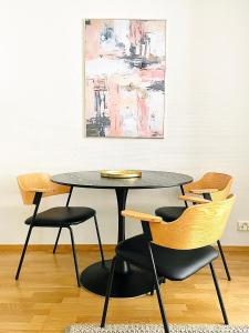 een tafel en stoelen in een kamer met een schilderij bij Luotsi 1911 Suite in Helsinki