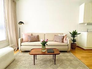 a living room with a couch and a table at Luotsi 1911 Suite in Helsinki