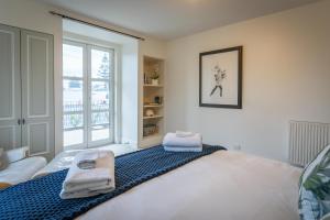 a bedroom with a bed and a large window at Sumner Surf Break Apt 2 in Christchurch