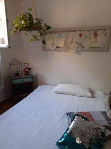 um quarto com uma cama branca e uma planta na parede em La casa sulla vecchia riva em Ferrara