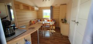 eine kleine Küche mit einem Tisch und einem Esszimmer in der Unterkunft MH135 camping TOHAPI NOVELA - Mobil home 5p climatisé - in Port-la-Nouvelle