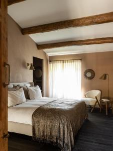 - une chambre avec un grand lit et une fenêtre dans l'établissement Terres Rouges, à Maussane-les-Alpilles