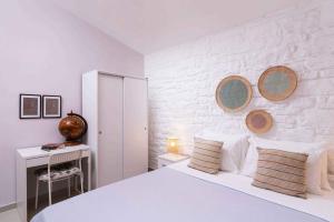 1 dormitorio con 1 cama blanca y 2 espejos en la pared en Villa Repsimia with Private Jacuzzi en Kókkinos Pírgos