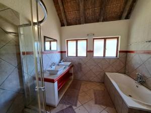 a bathroom with two sinks and a tub and a shower at Izintaba Private Game Reserve Waterberg in Vaalwater