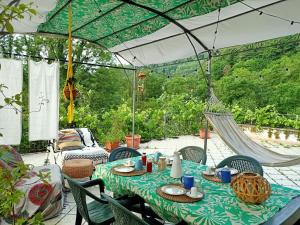 une terrasse avec une table, des chaises et un parasol dans l'établissement Amrita Rosa, à Castellamonte