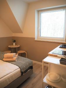 1 dormitorio con cama, ventana y mesa en Ruchome Piaski, en Łeba