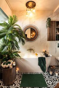 a bathroom with a tub and a palm tree at Qult - Jumanji in Bucharest